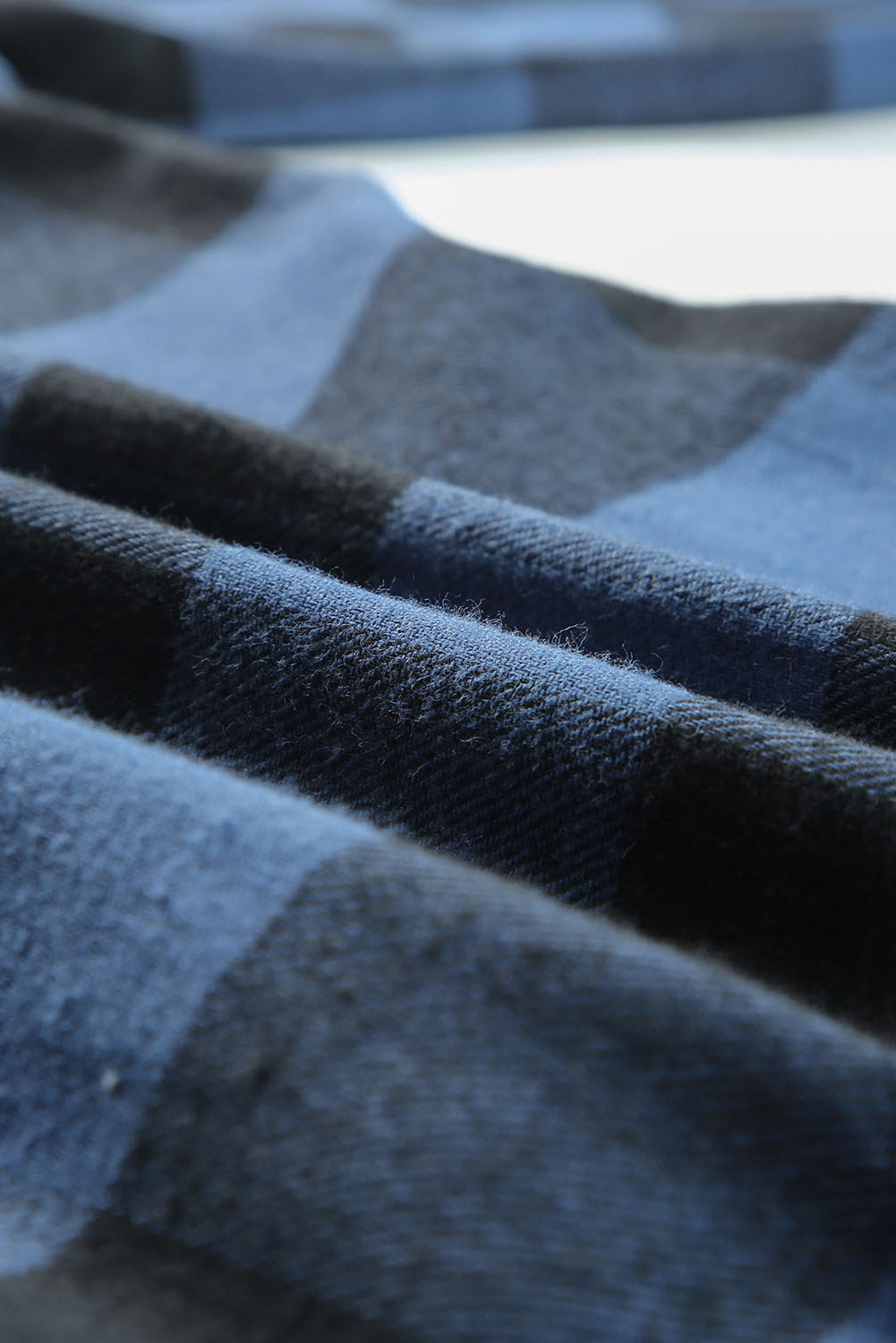 Chemise veste à carreaux bleue à col rabattu.
