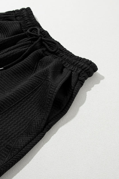 Haut noir à volants texturés avec fente et short à cordon de serrage