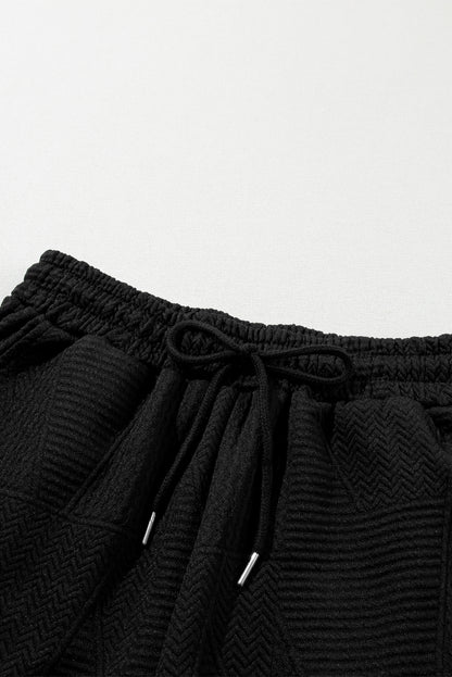 Haut noir à volants texturés avec fente et short à cordon de serrage